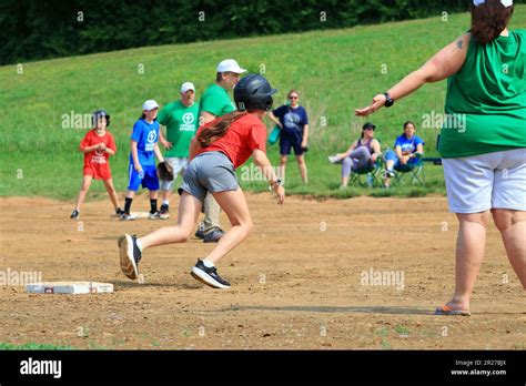 Preteen Girls Running Towards Home Plate During A Softball Game Stock