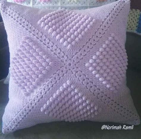 A White Knitted Pillow Sitting On Top Of A Couch