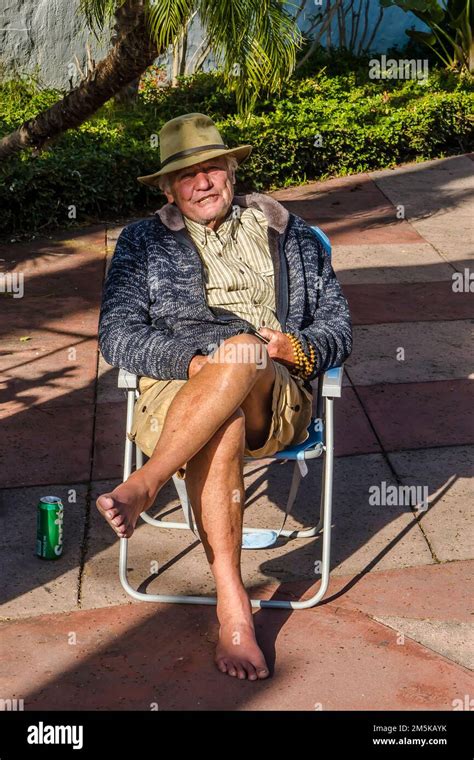 76 Year Old Male Sunbather Enjoying Himself On His Birthday Sitting On A Lawn Chair On The De