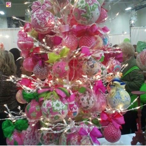 A Christmas Tree Decorated With Pink Green And White Ornaments In An