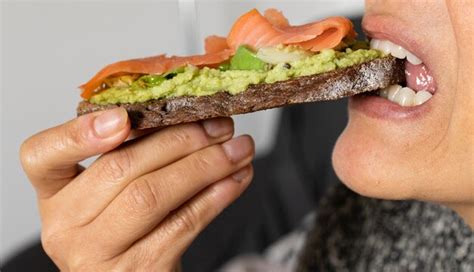 Boca De Mujer Comiendo Una Tostada De Pan Integral Con Aguacate Y