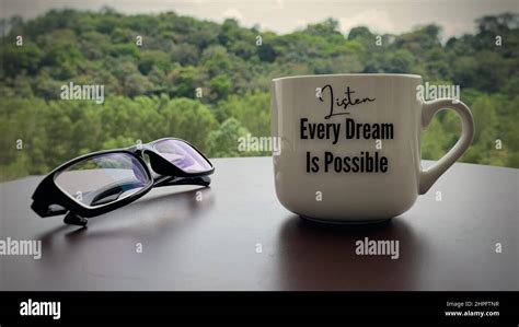 Motivational And Inspirational Quote On Coffee Cup Every Dream Is Possible With Glasses And