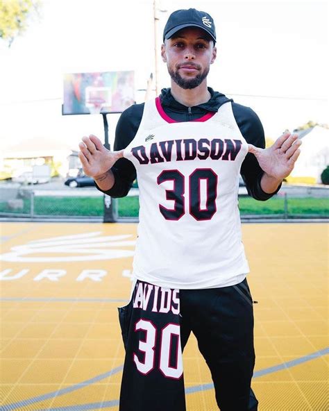 A Man Standing On Top Of A Basketball Court Holding His Hands In Front