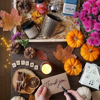 A Person Writing On A Piece Of Paper Surrounded By Autumn Decorations