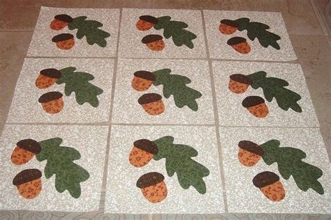 A Quilted Table Topper With Leaves And Acorns On It Sitting On The Floor