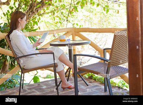 Woman Reading E Book On Balcony Stock Photo Alamy