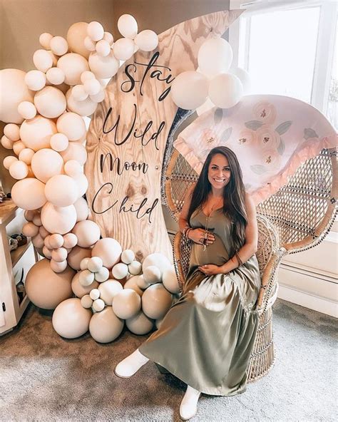 A Woman Sitting On A Chair In Front Of Balloons