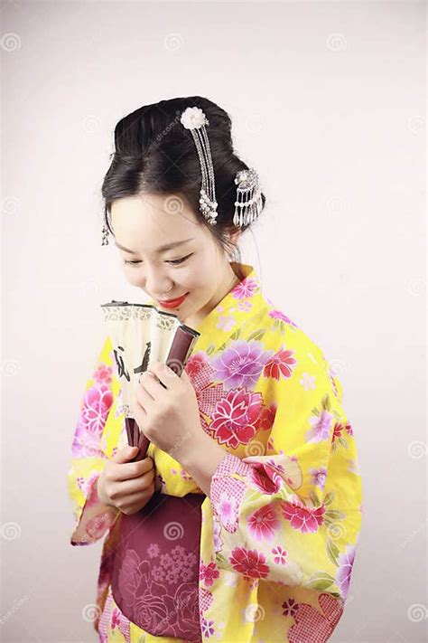 Traditional Asian Japanese Beautiful Geisha Woman Wears Kimono Smile And Hold A Fan On Hand On A