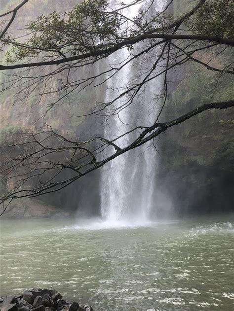 There Is A Waterfall In The Middle Of The Water With Rocks Under It And