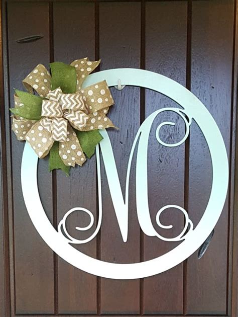 a monogrammed door hanger with a bow on it's front door