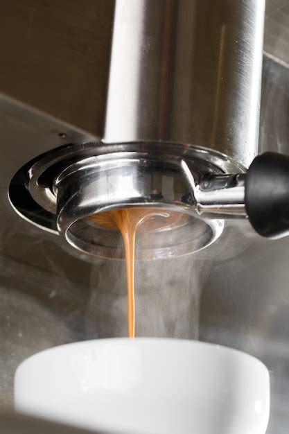 Verter el flujo de café de la máquina profesional en la taza barista