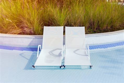 Dos tumbonas en el agua están en la piscina hotel vacaciones de