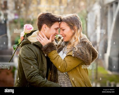 Candid Portrait Of Beautiful European Couple With Rose In Love Kissing