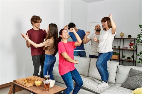 Grupo de jovens amigos hispânicos dançando em casa Foto Premium