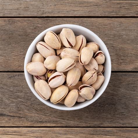 Premium Photo Salted Roasted Pistachios On A Bowl Over Wooden Table