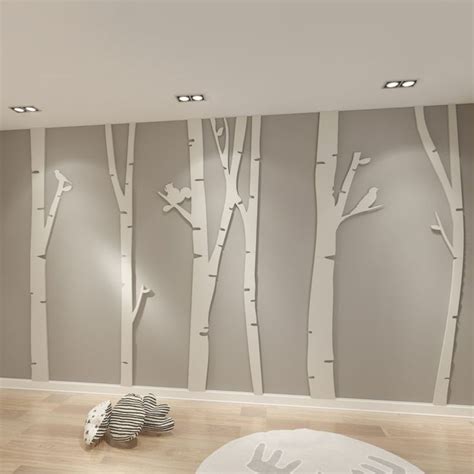 A Room With White Trees Painted On The Wall And Wooden Flooring In