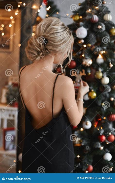 Mooie En Sexy Blonde Modelmeisje Met Een Madeliefje Haarstijl In De Zwarte Jurk Met Een Naakte