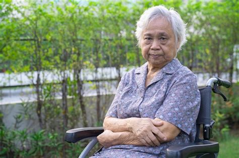 Anciana asiática anciana mujer paciente en silla de ruedas en el parque