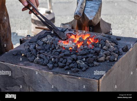 Red Hot Metal Being Forged In A Blacksmiths Fire In A Smith Next To An Anvil The Blacksmith Is