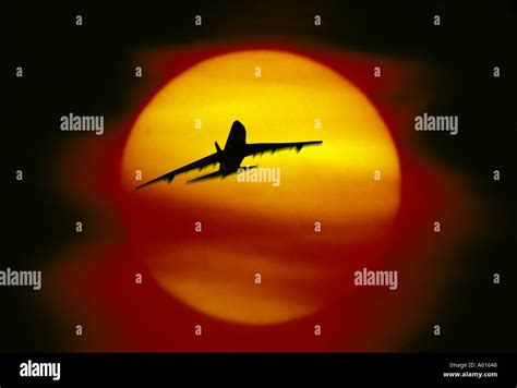 plane flying into sunset Stock Photo - Alamy