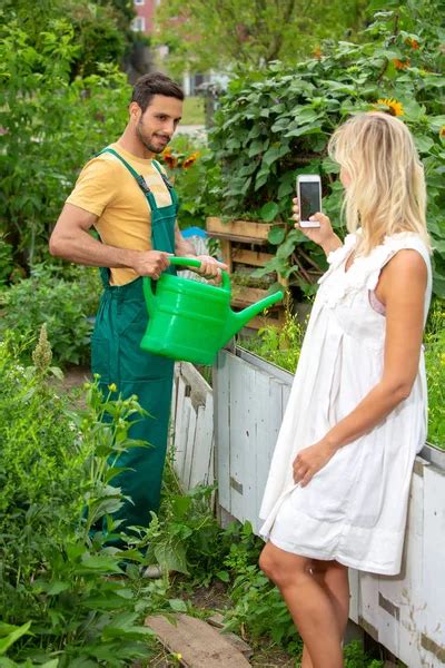 Shirtless Gardener With Straw Hat Watering Flowers Stock Photo