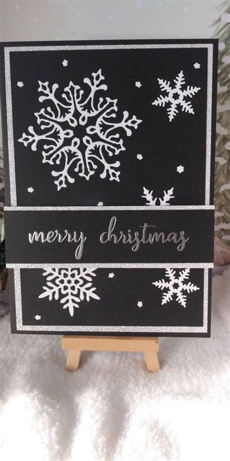 A Black And White Christmas Card With Snowflakes