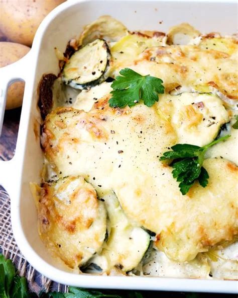 A Casserole Dish With Zucchini Cheese And Parsley In It