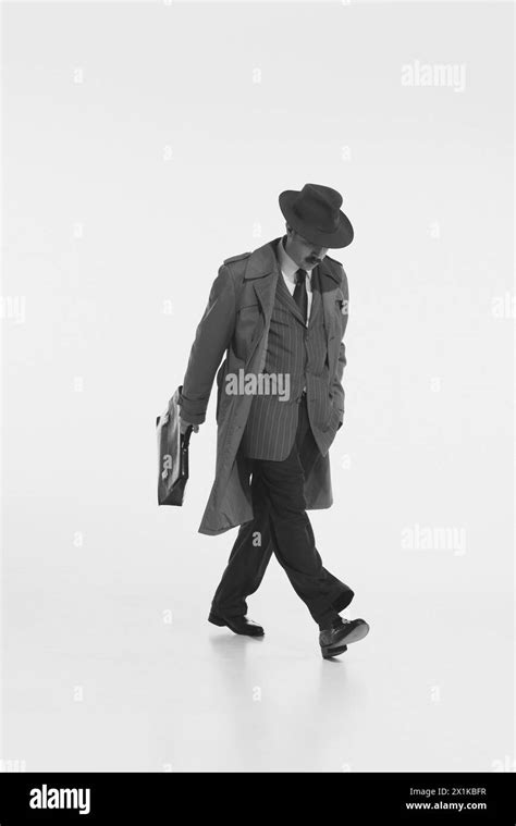 Man In Suit Fedora Hat And Trench Coat Walks With Briefcase Capturing