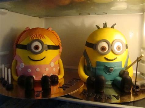 Two Cakes Made To Look Like Minion Characters Sitting On Top Of Each