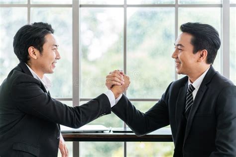 Asian Businessmen Arm Wrestle Handshake For The Teamwork Of Business