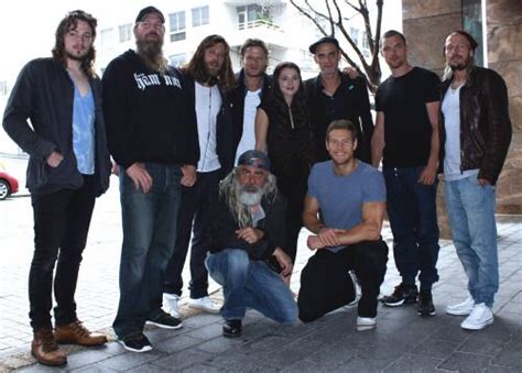 A Group Of Men Standing Next To Each Other In Front Of A Building With