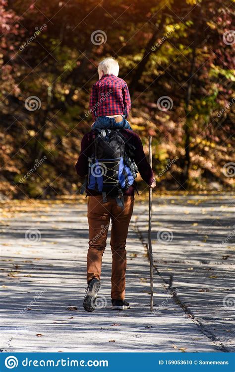 Father With Son On His Shoulders Walking In The Autumn Park Sunny Day