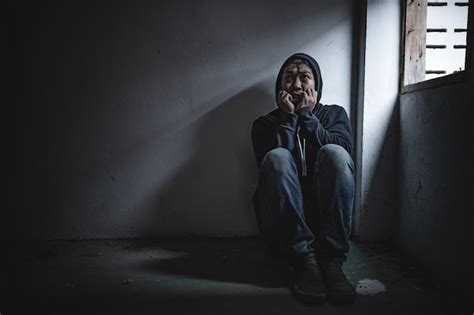 Homem asiático viciado em drogas num lugar deserto um viciado sente se