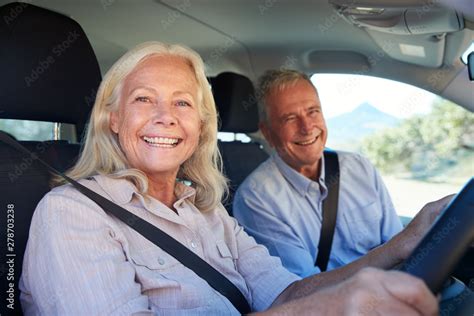 Senior White Woman And Her Husband Driving In Their Car Smiling To