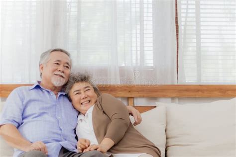 Happy Asian Senior Couple Stay Together On Sofa At Home In Romantic