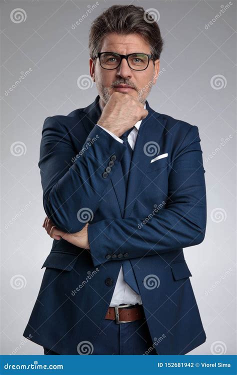 Thoughtful Old Businessman Holding His Hand On His Chin Stock Photo