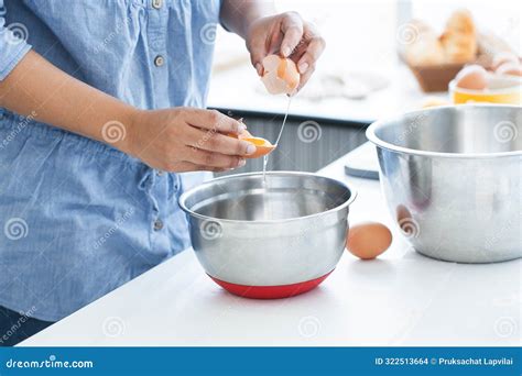 Woman Hands Cracking An Egg To Separate Egg Yolk From Egg White Into