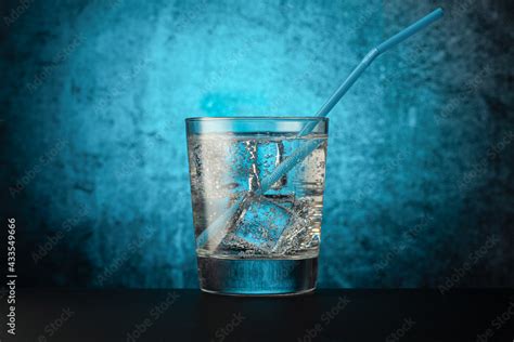 Glass Glass With Mineral Water With Ice And A Drinking Tube On A Dark