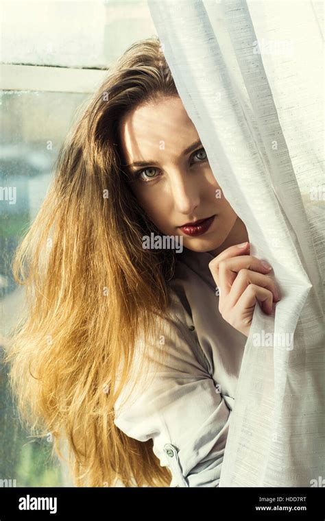 Beautiful Young Woman Hiding Behind The Blinds Stock Photo Alamy