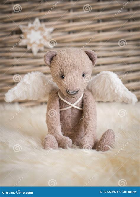 A Teddy Bear With Angel Wings Sits On The Background Of A Wicker Basket