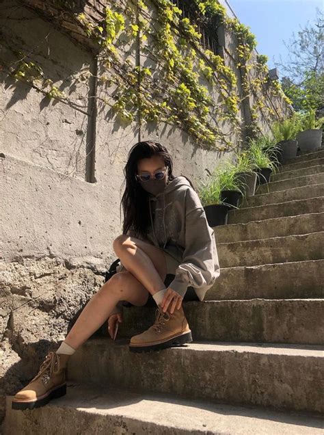 A Woman Sitting On Some Steps Wearing A Mask