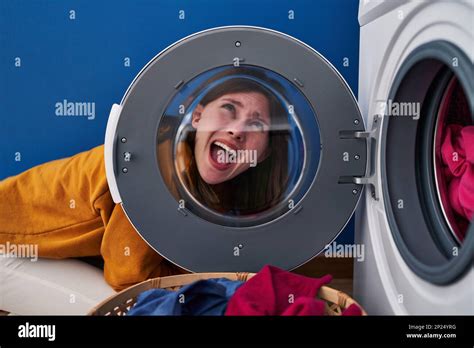 Young Brunette Woman Looking Through The Washing Machine Window Angry