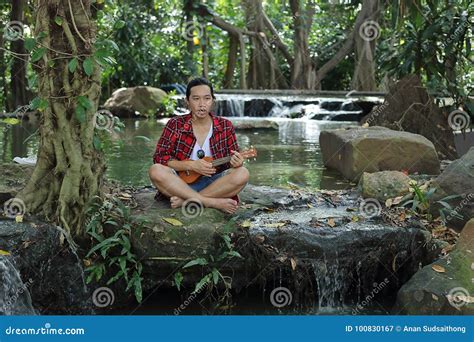 Portrait Of Young Asian Man Playing Ukulele In Beautiful Nature