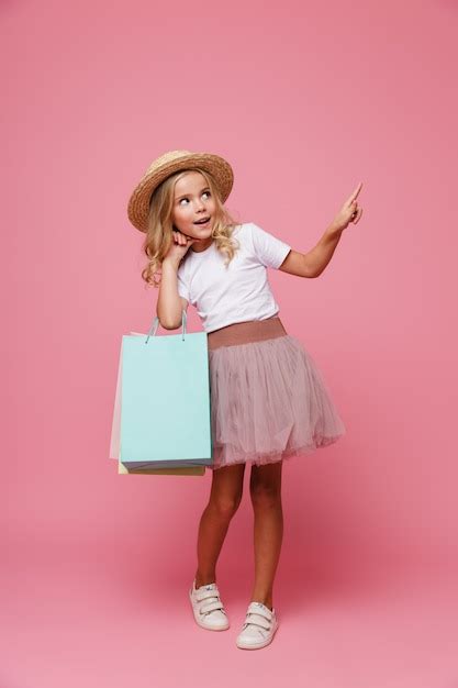 Retrato de cuerpo entero de una niña sonriente con sombrero Foto Gratis