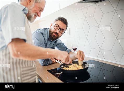 Adult Hipster Son And Senior Father Indoors In Kitchen At Home Cooking