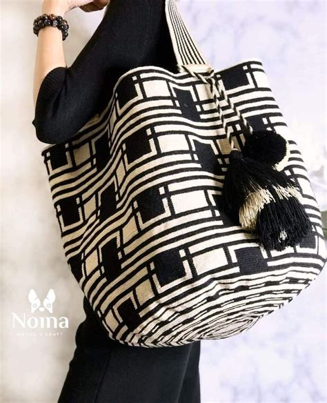 A Woman Is Holding A Black And White Bag