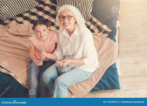 Belle Mamie Et Fille Souriant Dans Lappareil Photo Tout En Tricotant Photo Stock Image Du