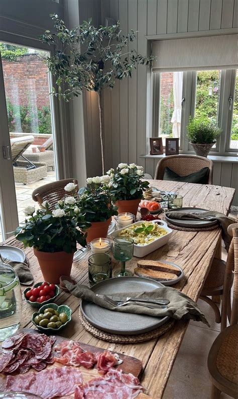 a wooden table topped with lots of plates and bowls filled with food ...