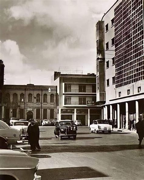 An Old Black And White Photo Of Cars Parked On The Side Of A Road In