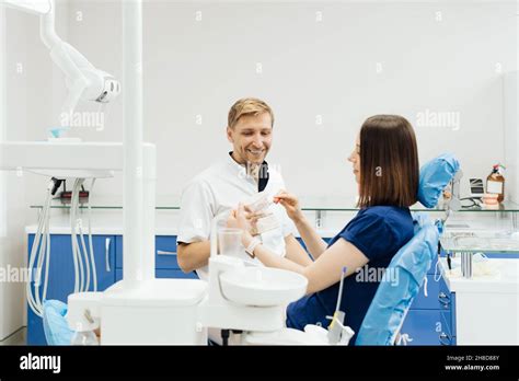 Dentist Showing The Correct Dental Hygiene Using Mock Up Of Skeleton Of